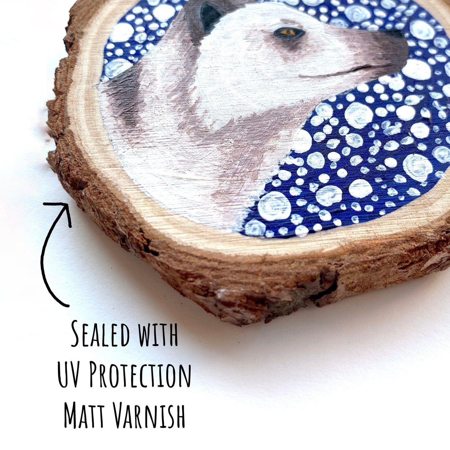 Arctic Fox Wood Slice Ornament close up showing the painted details. with text sealed with uv protection matt varnish.