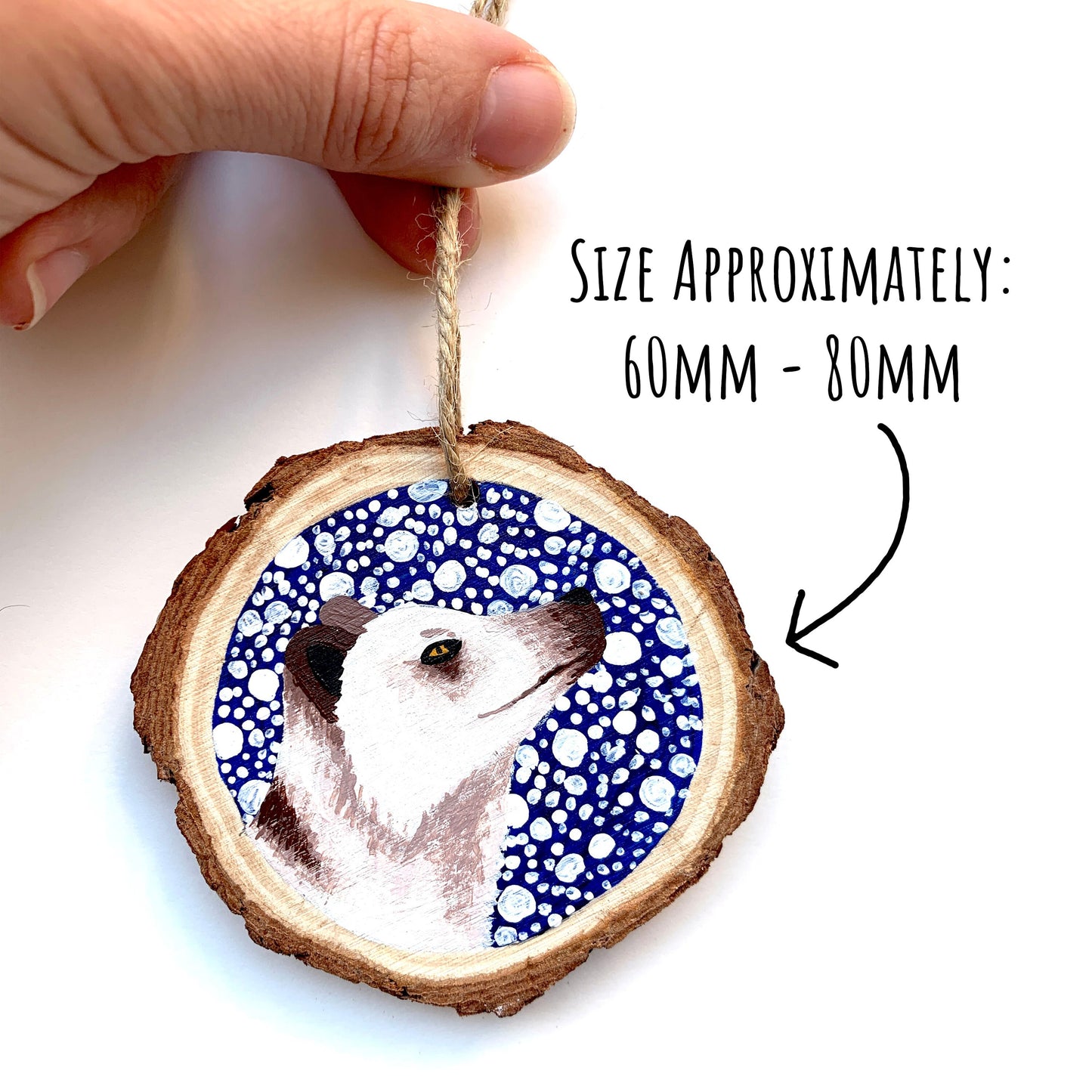 Arctic Fox Wood Slice Ornament being held up on a white background with the text size approximately 60mm - 80mm.