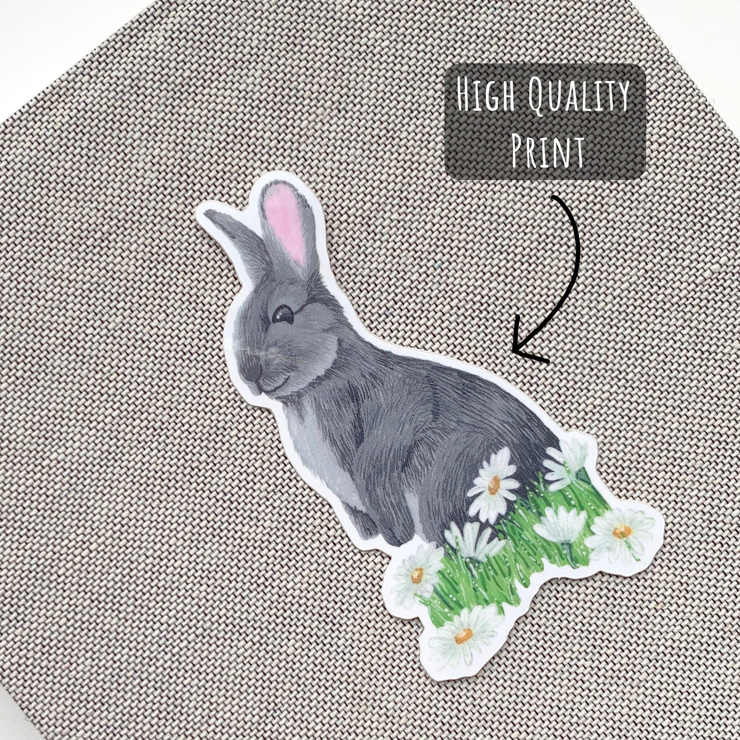 Little Wild Rabbit and Daisies Sticker placed on to the front of a grey notebook with the text high quality print.
