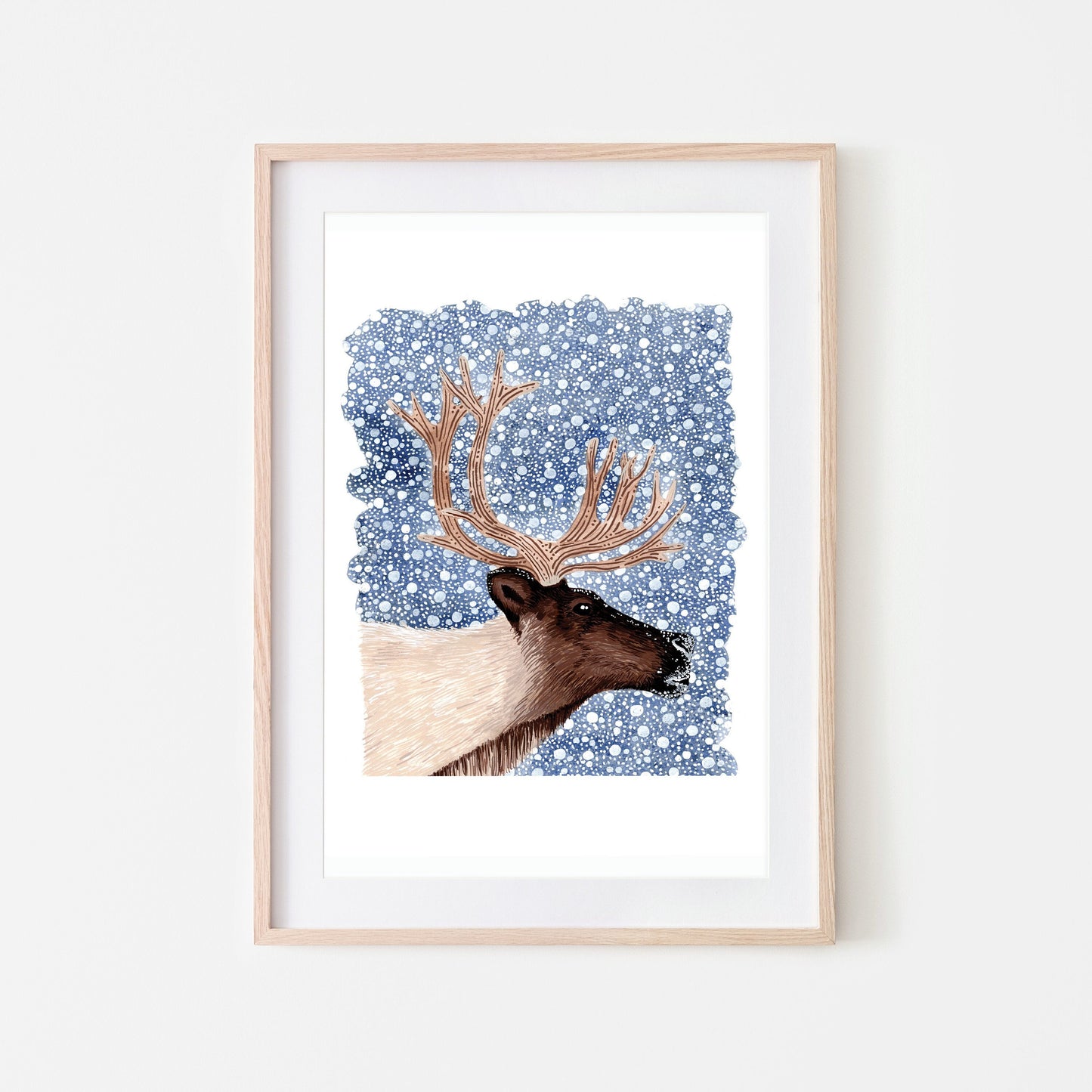 A framed art print of a reindeer with a dark blue snowy background.