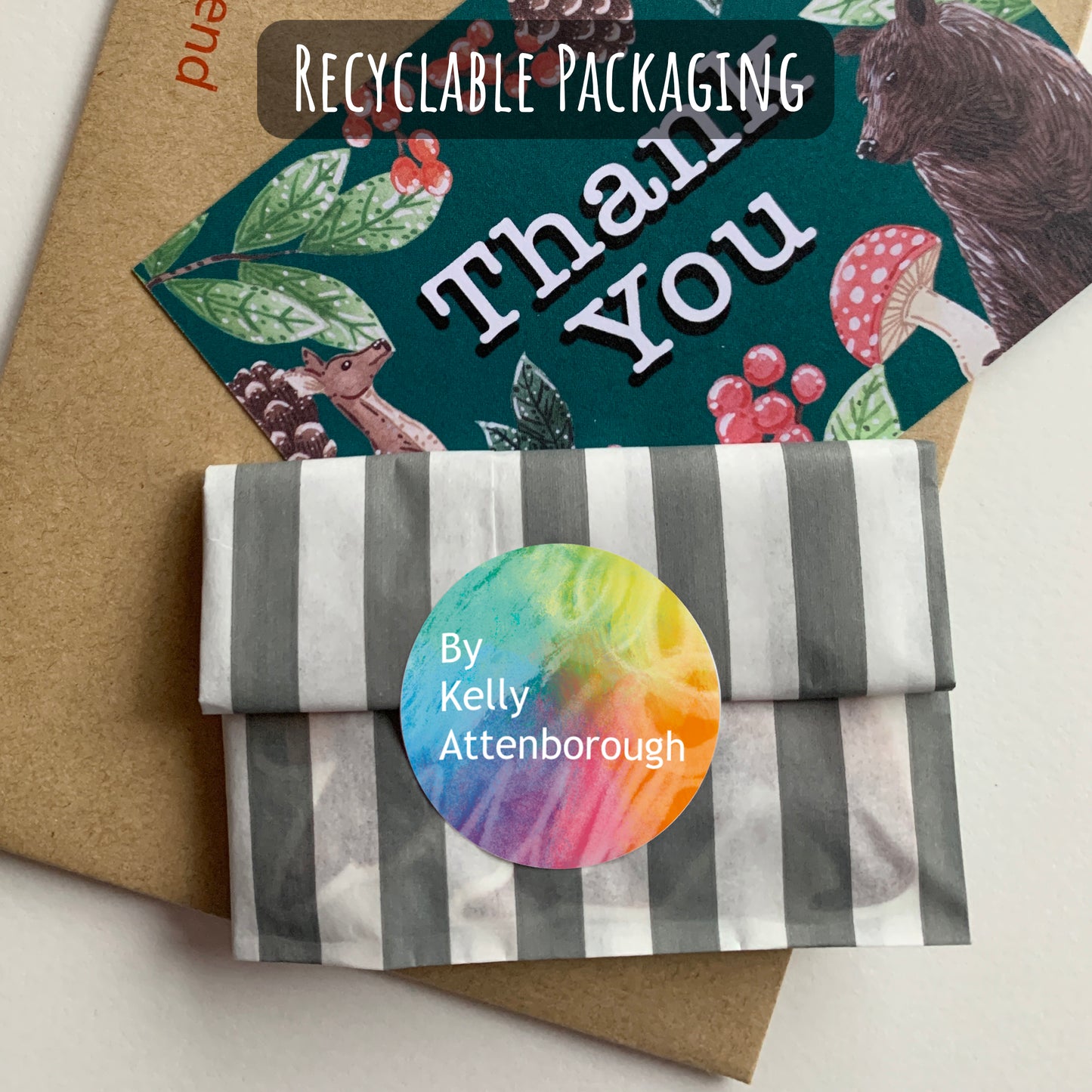 Recyclable packaging with a striped design and a colourful label, featuring a Thank You card and By Kelly Attenborough logo sticker