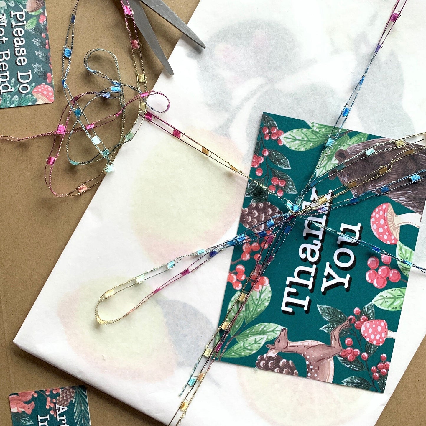 a artwork/print wrapped up in tissue with and backing board with a hard backed envelope and thank you card