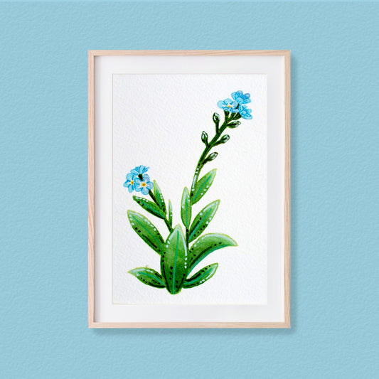 A framed mixed media original painting of a forget-me-not featuring a light wood frame on white, displayed against a textured pale blue wall.