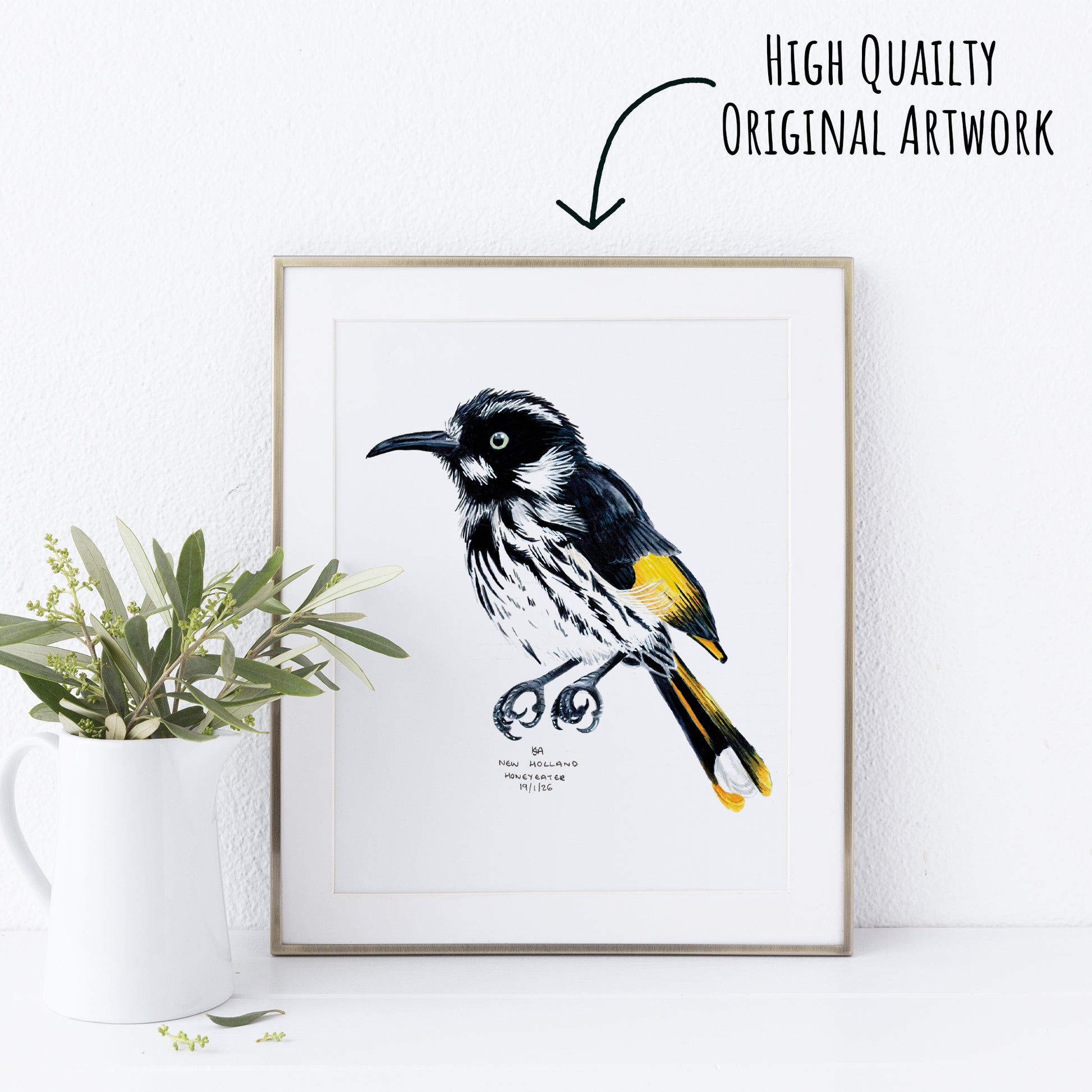 Framed artwork of a bird with a plant on a white surface