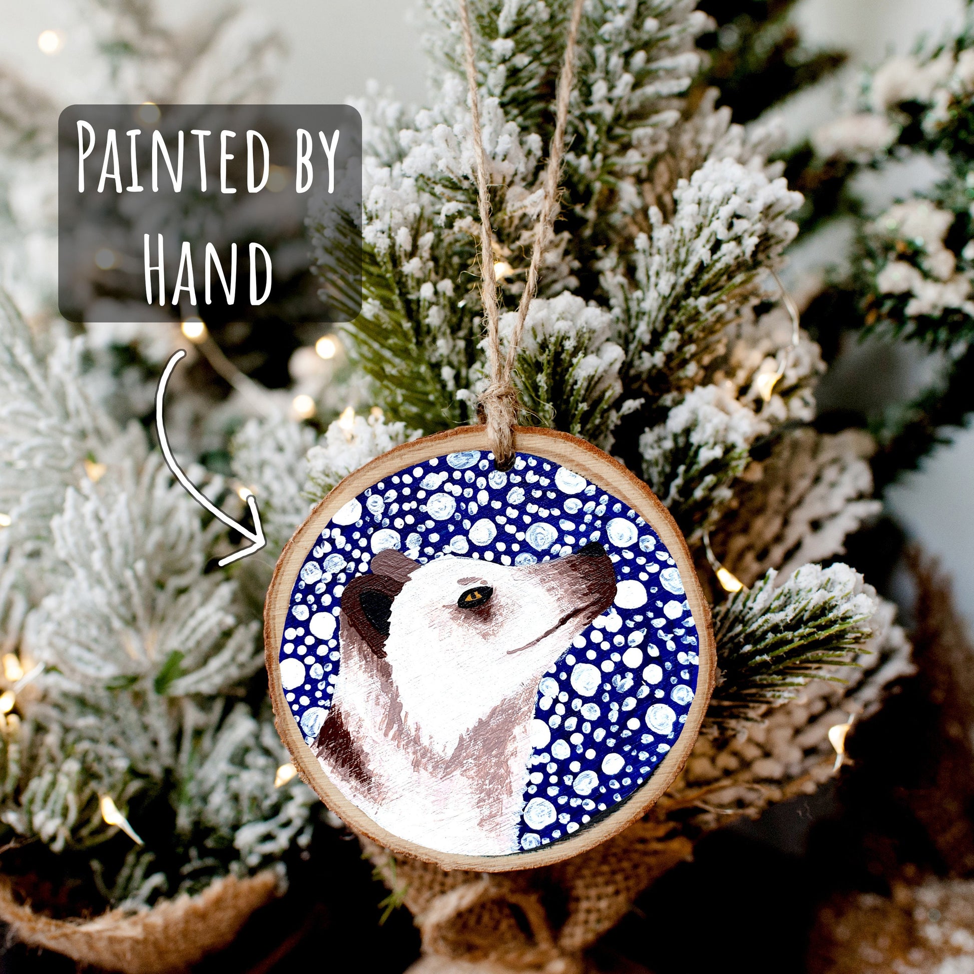 Arctic Fox Wood Slice Ornament hanging on a mini snowy Christmas tree with jute twine. Includes the font painted by hand.