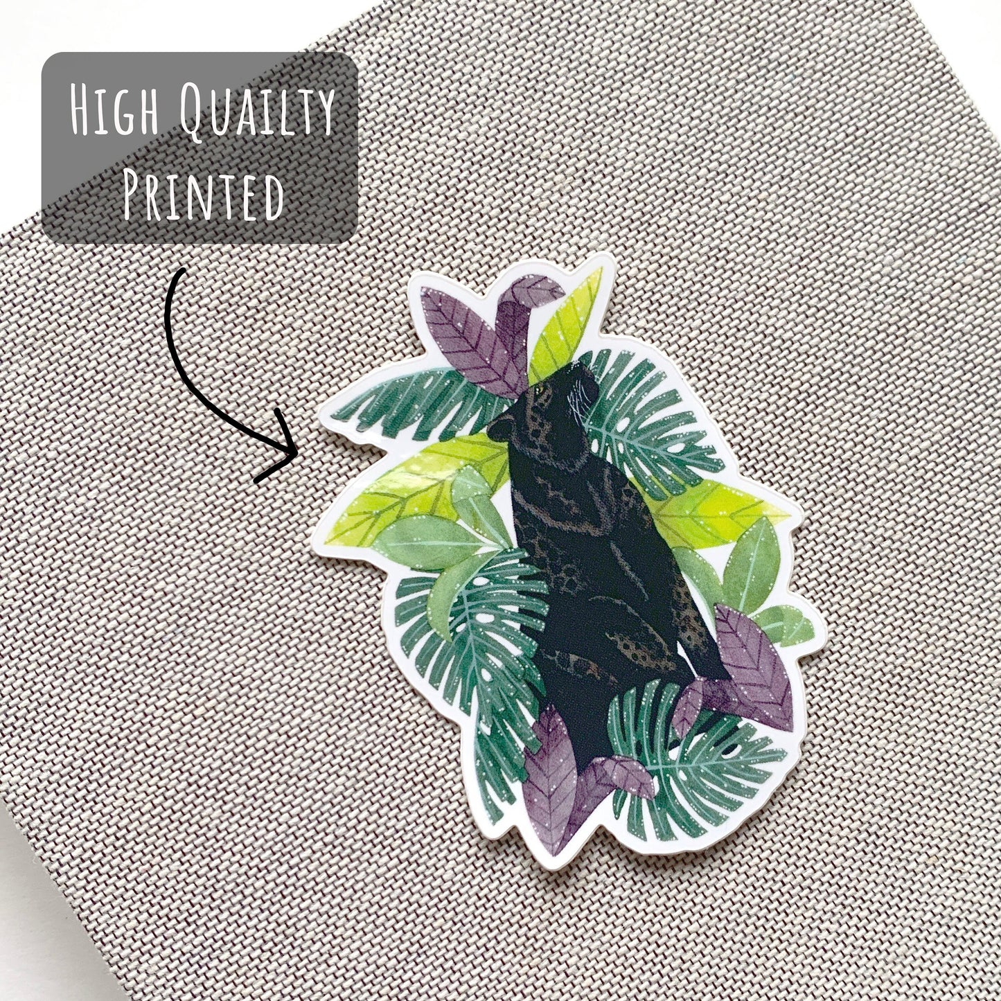 Black Leopard and Tropical Leaves Sticker on the front of a grey notebook with the text high quality printed.