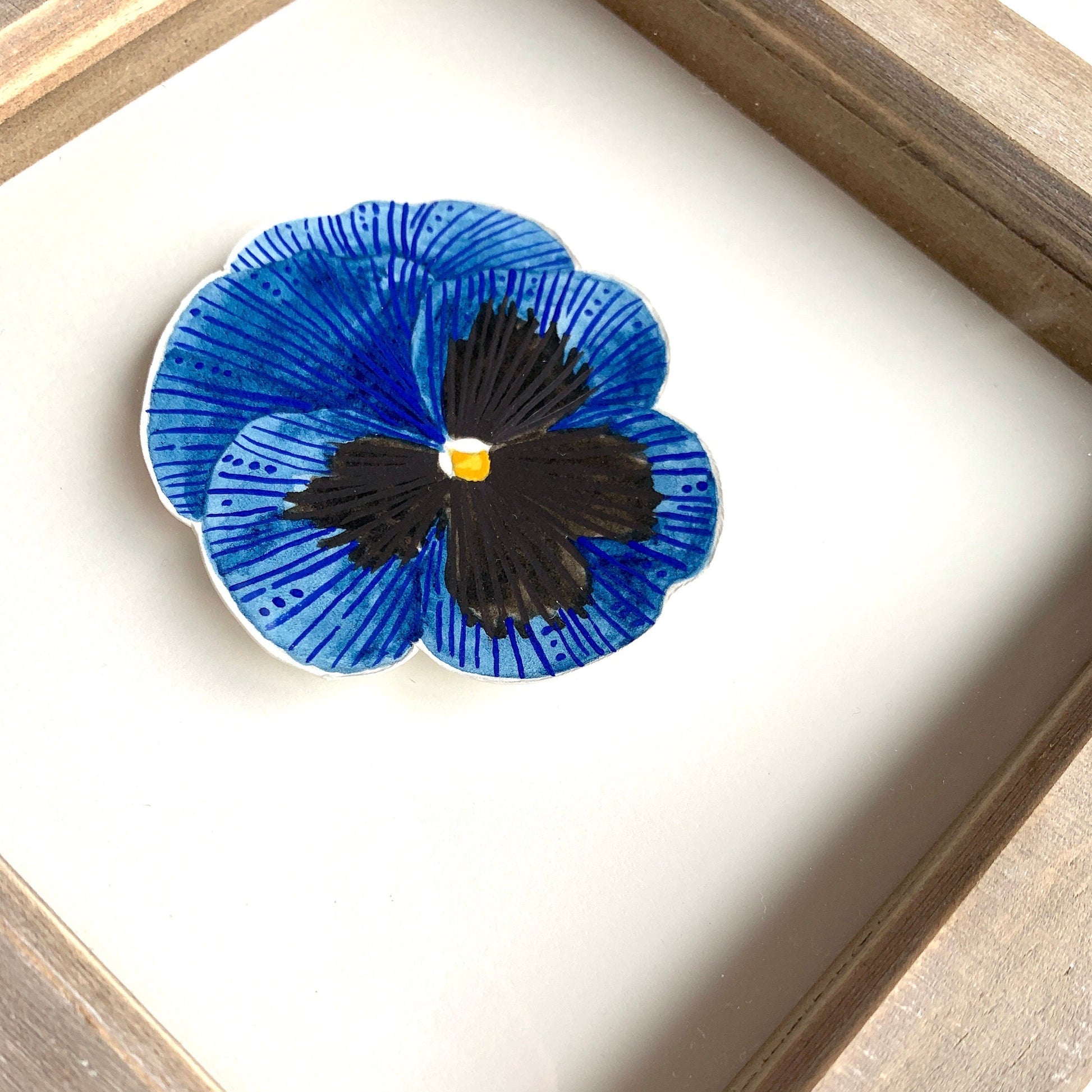 a close up of a blue and black pansy flower painting. painted in watercolour and gouache.