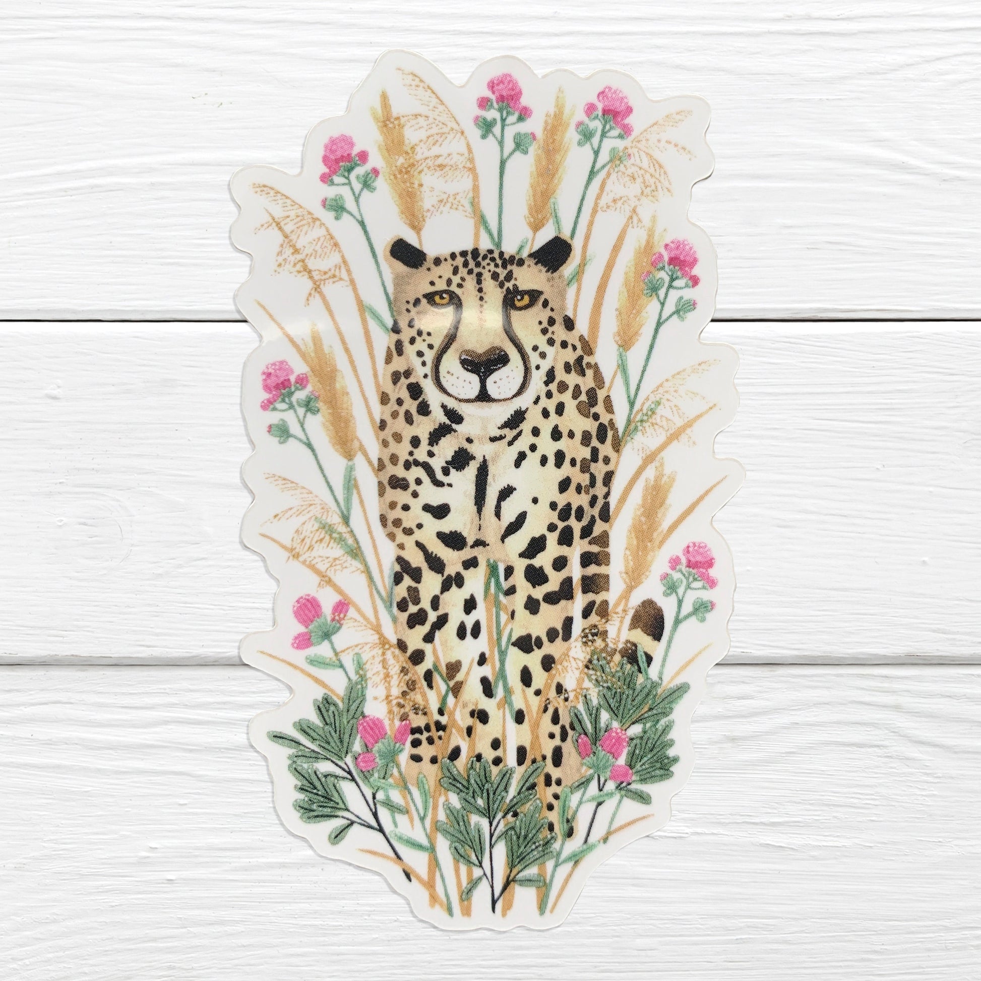 A sticker depicting a cheetah with a background of grasses and flowers.