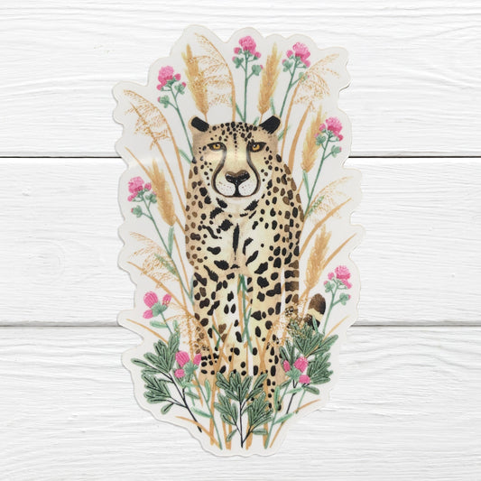 A sticker depicting a cheetah with a background of grasses and flowers.