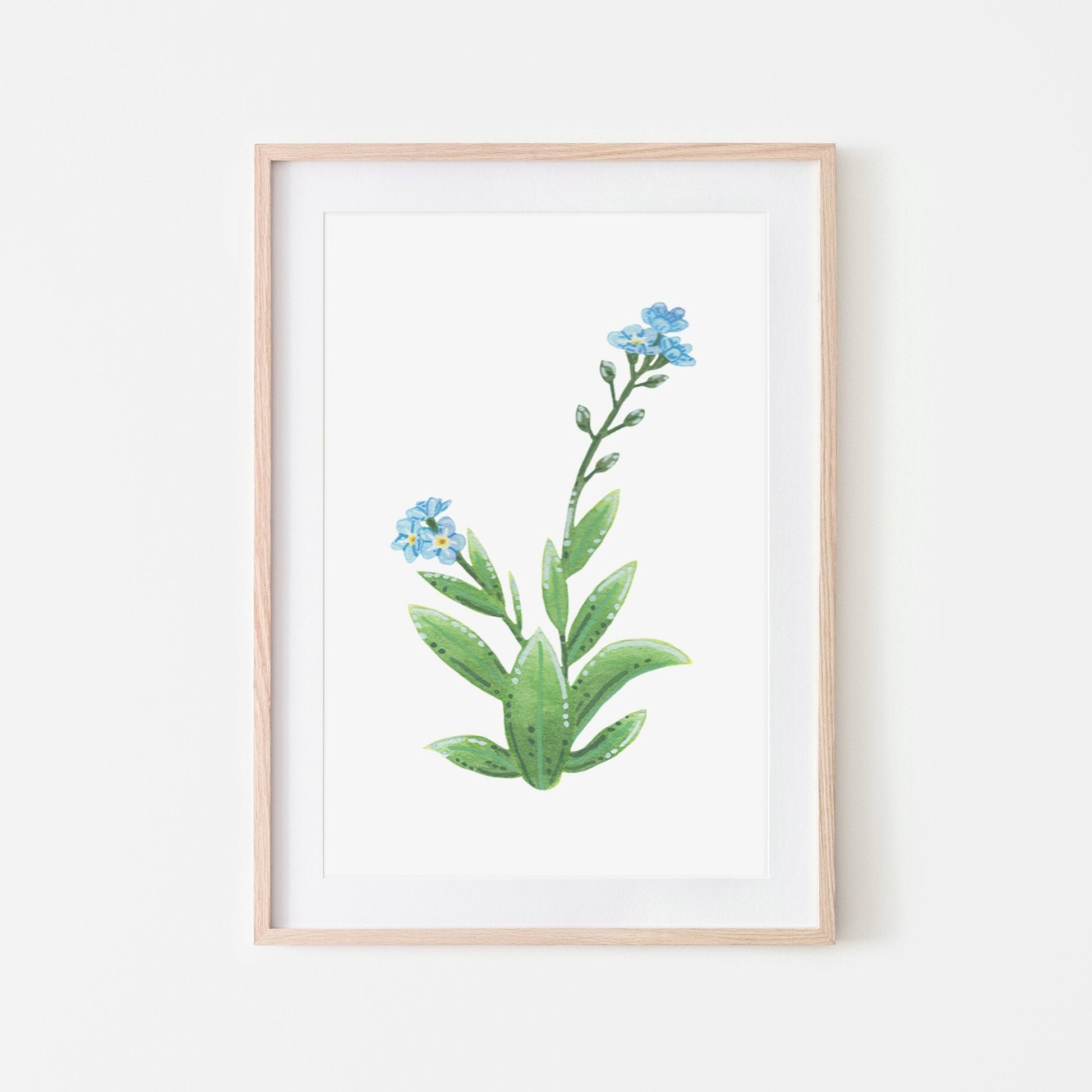 A hand-painted watercolor artwork of a blue forget-me-not flower with green leaves, mounted and framed for display.