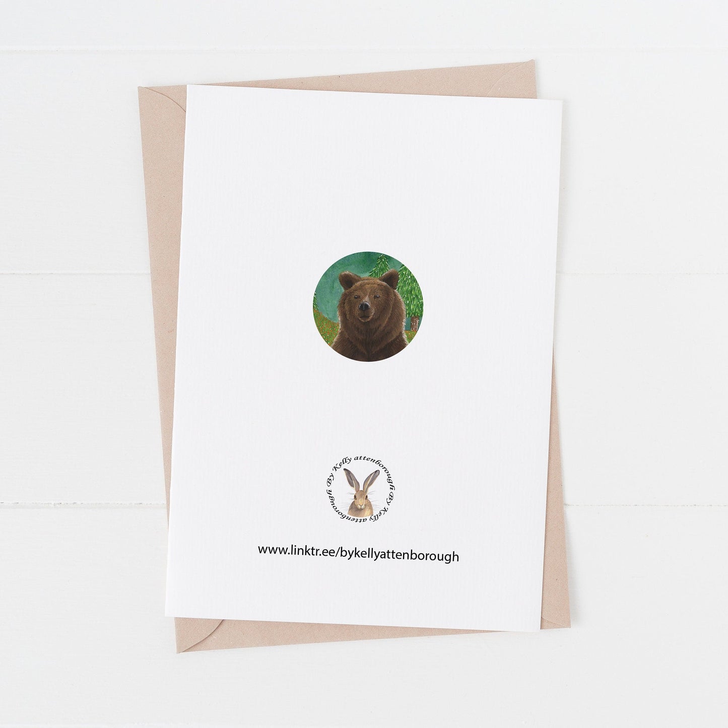 Grizzly Brown Bear Birthday card back with a brand logo and a circle of part of the illustration from the front of the card. card laying flat on a white suface.