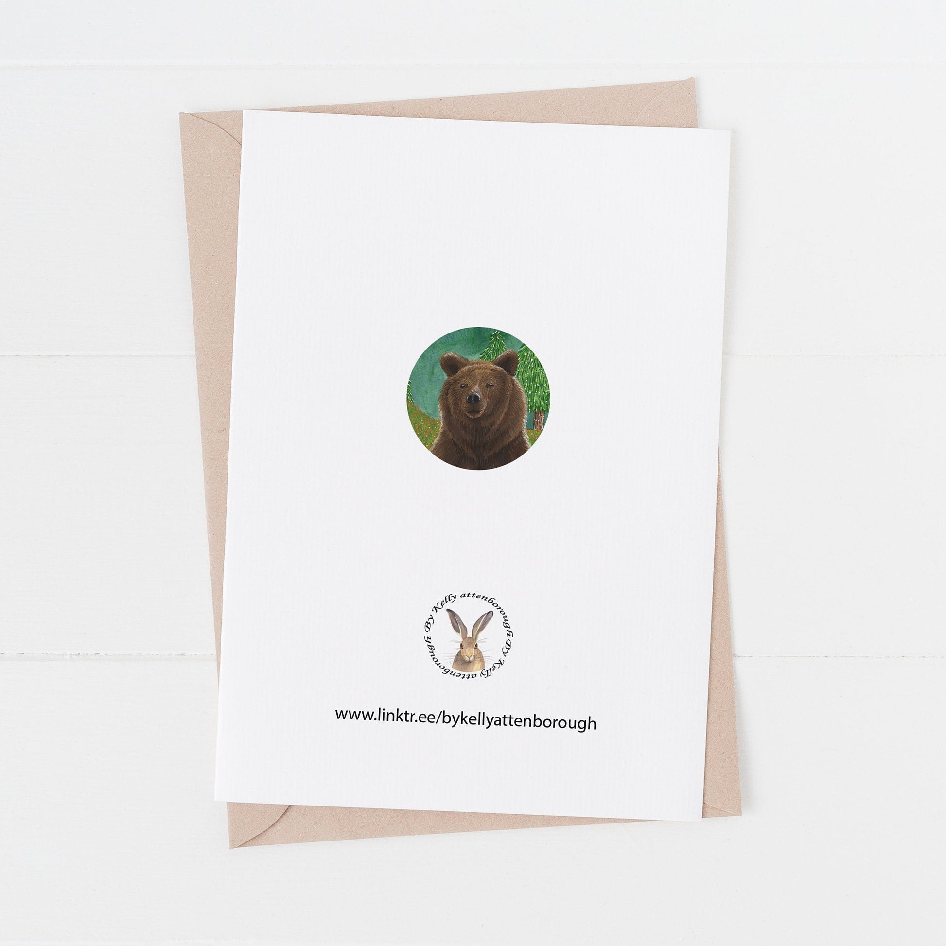 Grizzly Brown Bear Birthday card back with a brand logo and a circle of part of the illustration from the front of the card. card laying flat on a white suface.