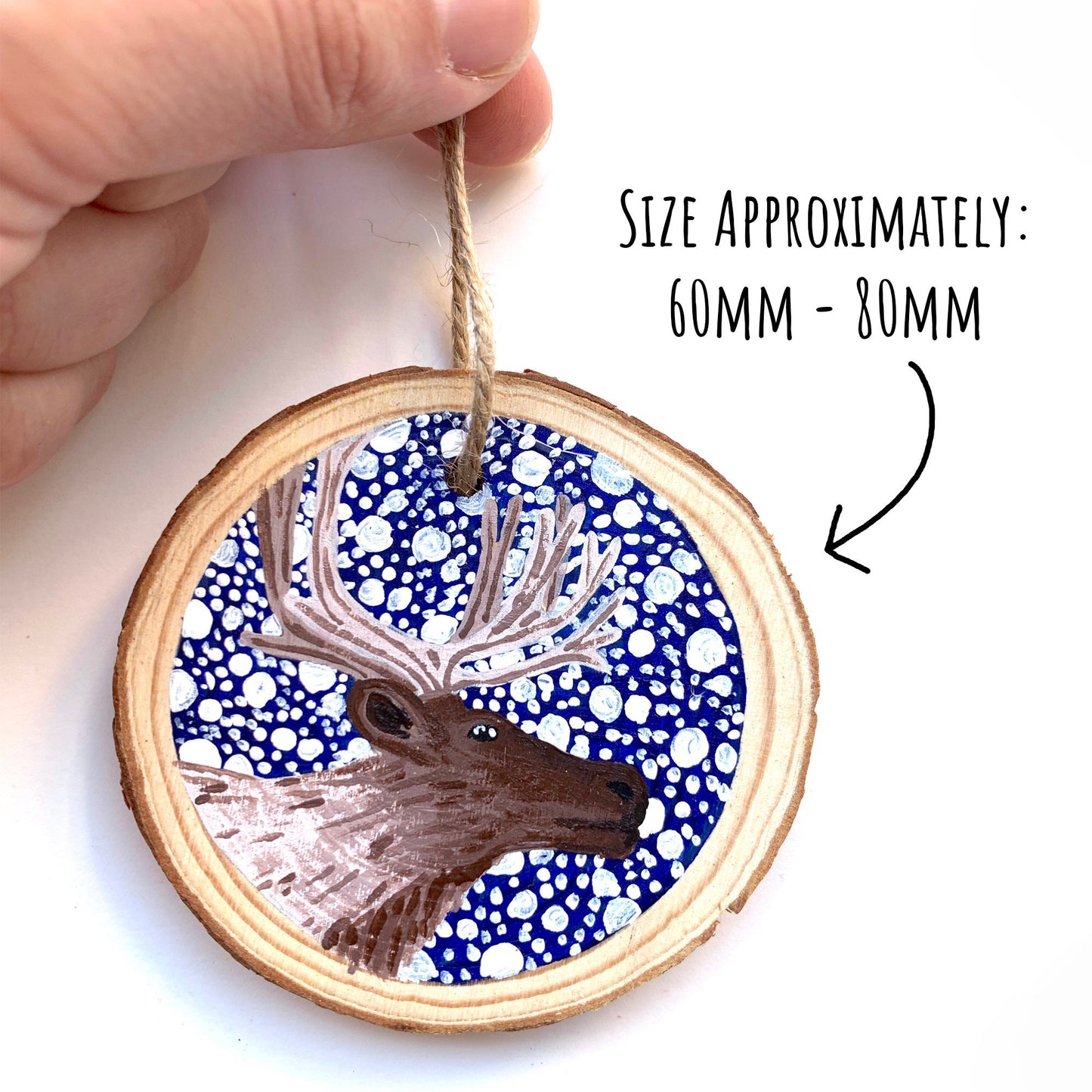 Hand Painted Reindeer Wood Slice Ornament being held up on a white background with the text size approximately: 60mm-80mm.