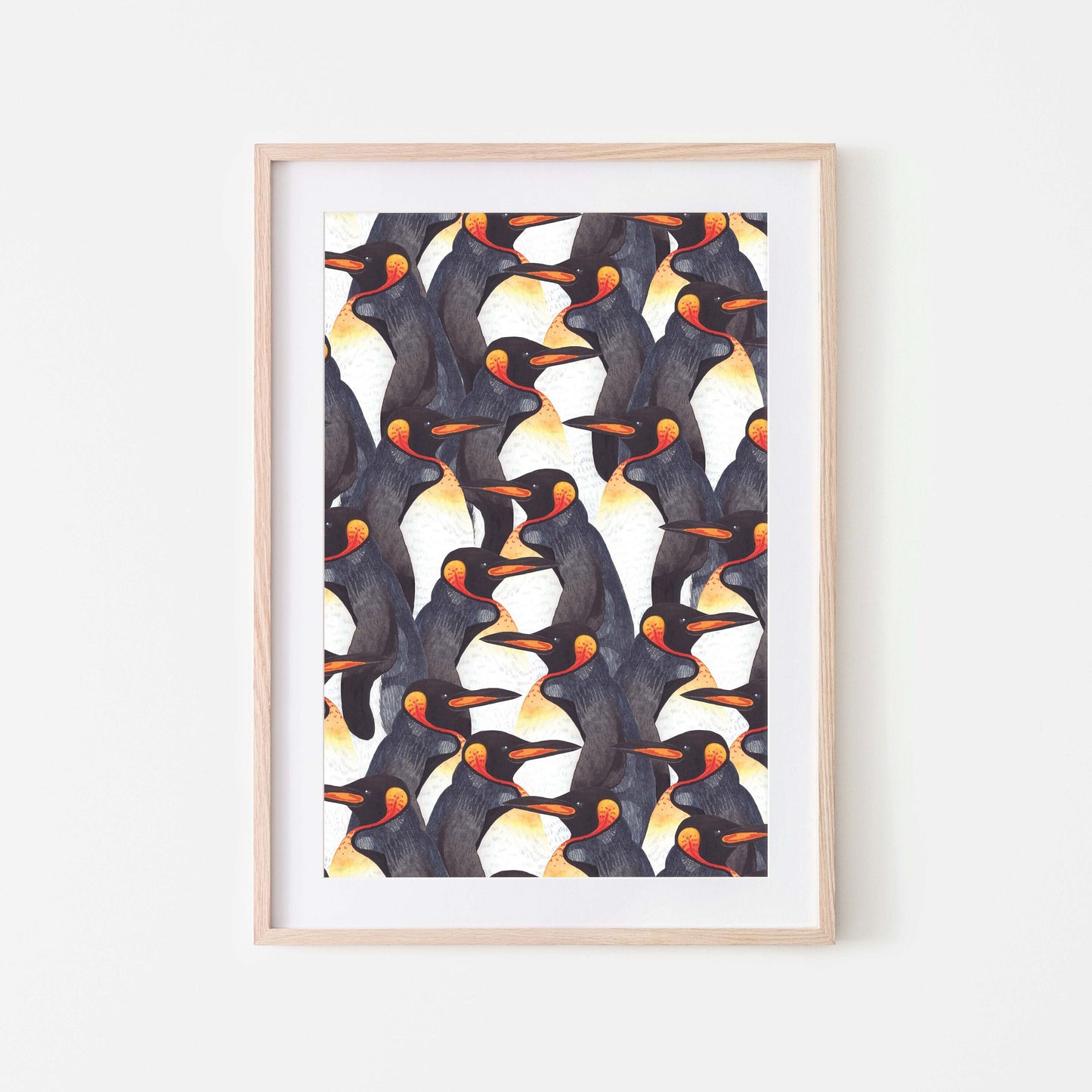 Framed watercolour art print of king penguins displayed on a white wall.