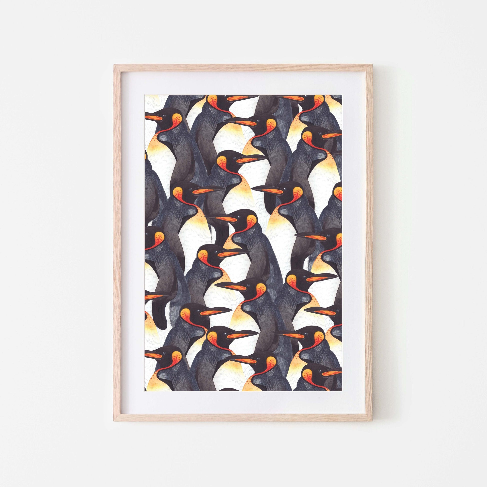 Framed watercolour art print of king penguins displayed on a white wall.