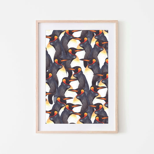 Framed watercolour art print of king penguins displayed on a white wall.