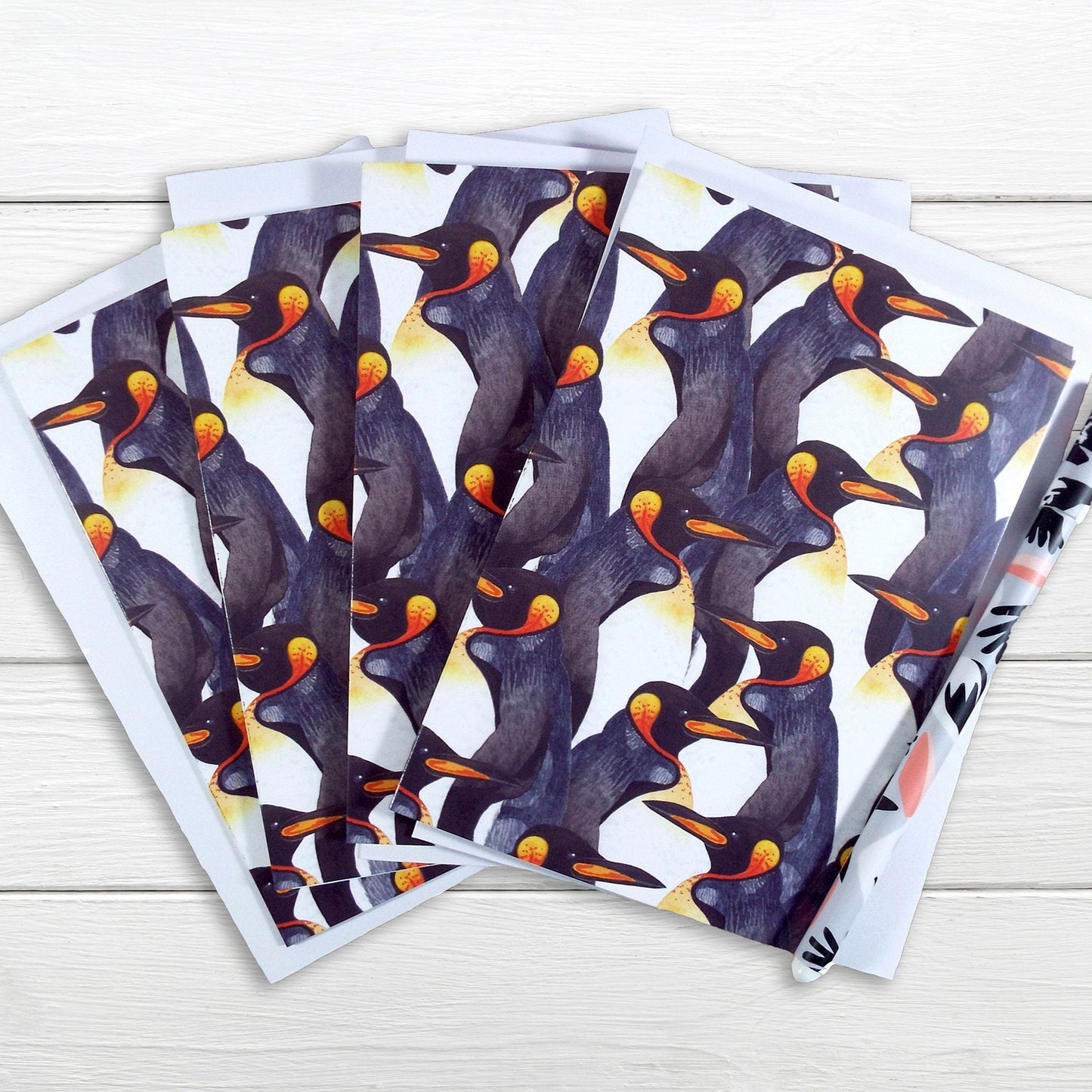 A set of note cards with a watercolour penguin pattern displayed on a white surface. pack of 4 cards.