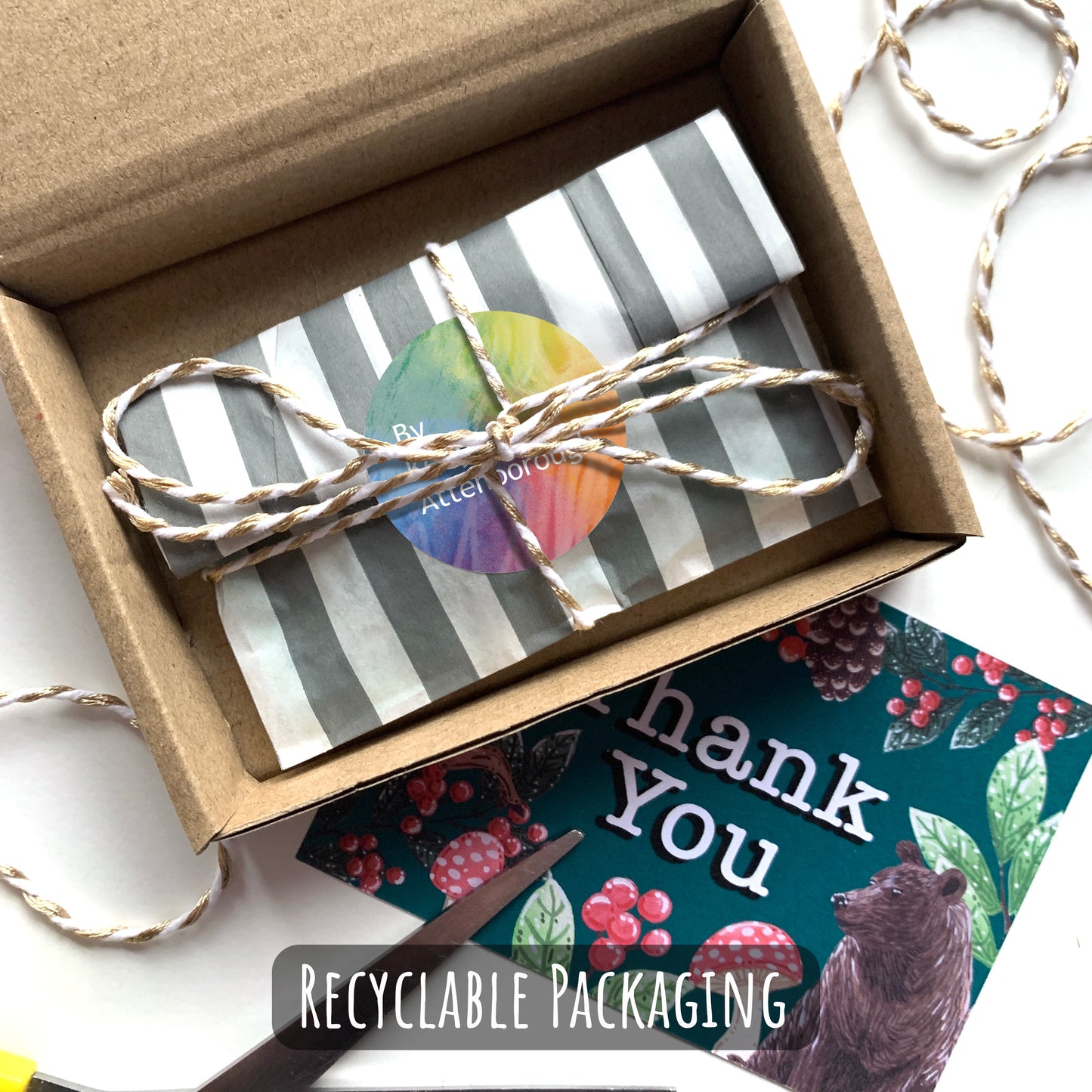 Showing how your pin badge will be packaged. placed into a paper sleeve and wrapped up with string and with a brand logo sticker. placed into a small box with a thank you card.
