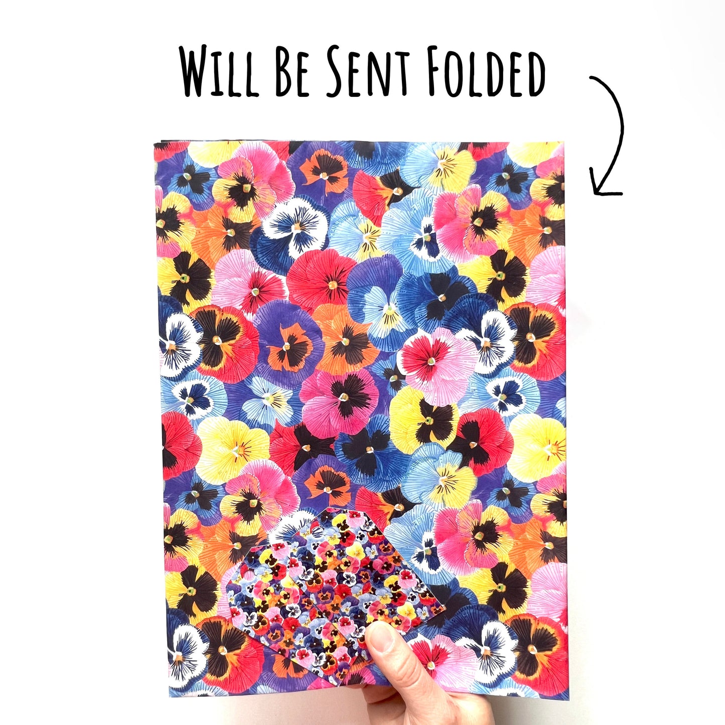 Pansy Flower Wrapping Paper folded and being held up against a white background with the text will be sent folded.
