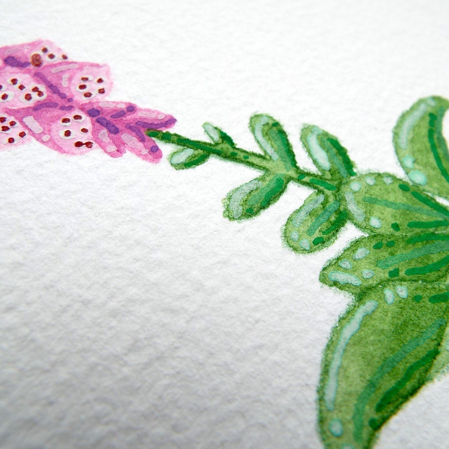 Close-up of a foxglove flower painting with pink flowers and green leaves on a textured white paper background.