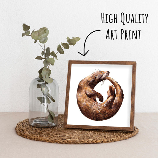 Playful Otter Art Print in a dark wood frame standing on a straw matt with a glass vase with a eucalyptus branch.