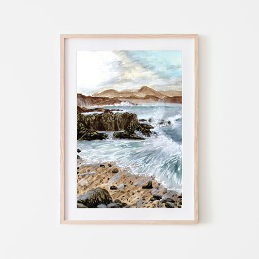 A framed art print depicting a coastal seascape with waves, rocks, and a breaking sun, set in a light wooden frame.