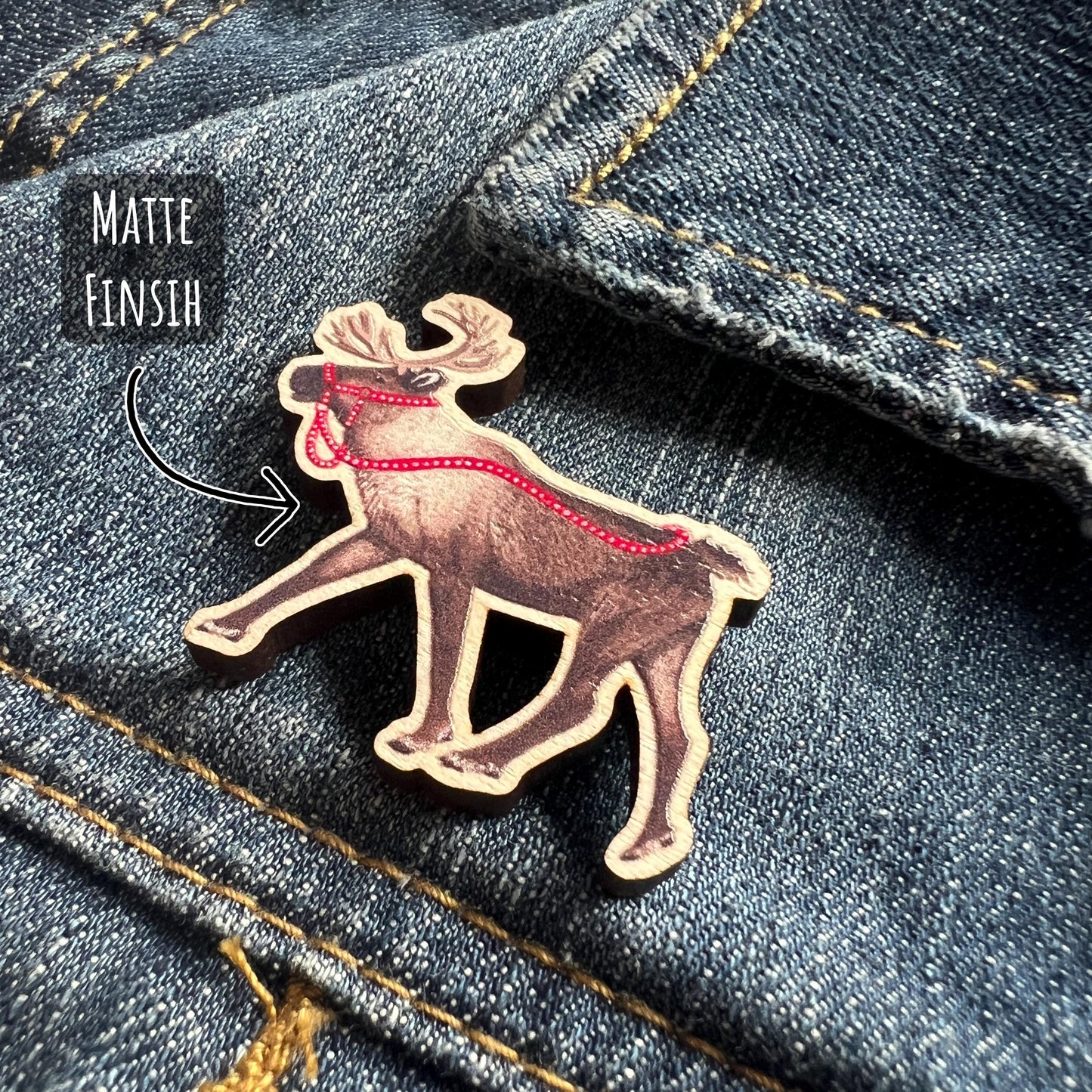 Reindeer Maple Wood Pin Badge close up showing the details and illustration qualities of this wooden pin badge. with the text matte finish.