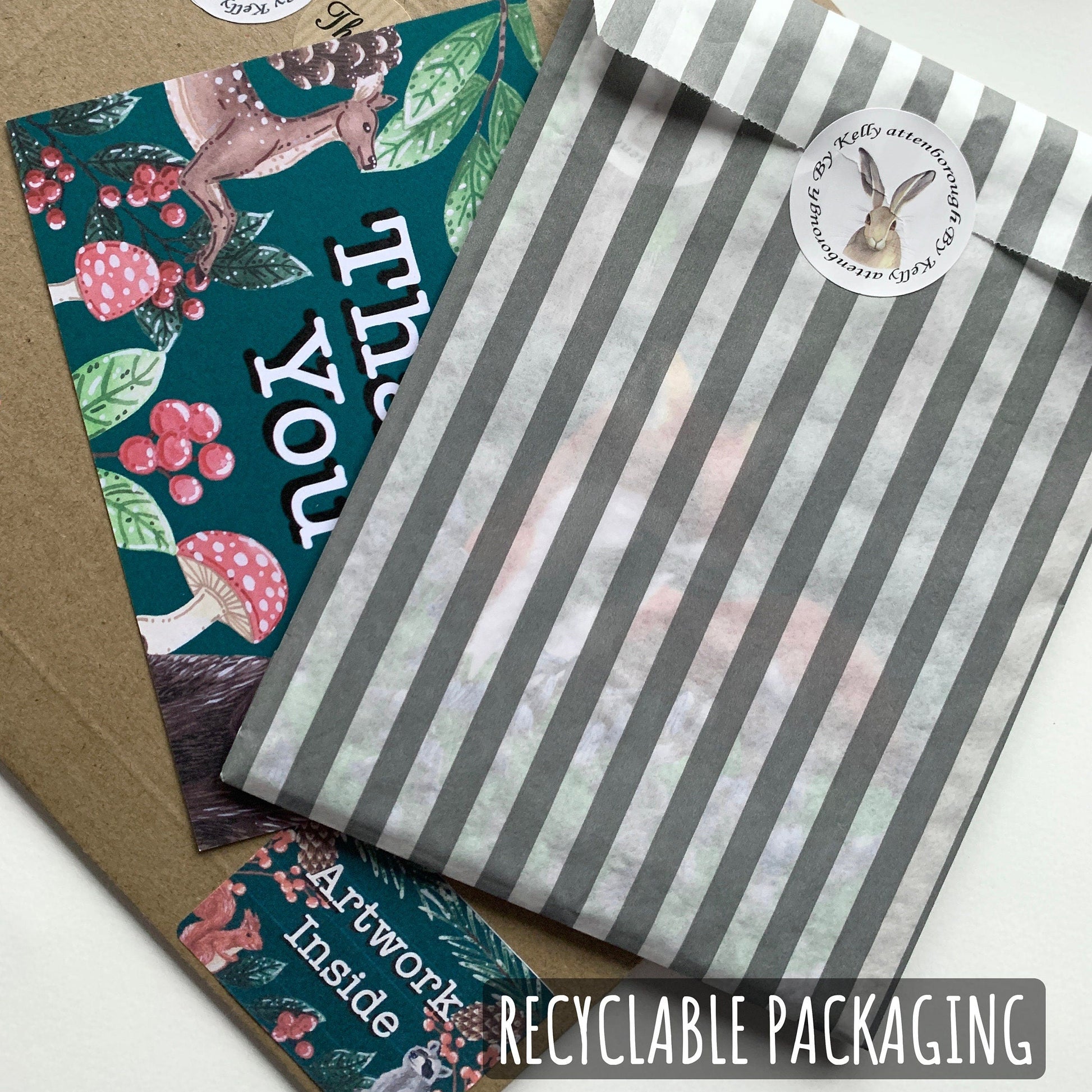 Recyclable packaging with a green card featuring mushrooms and text, a striped envelope, and a brown envelope.