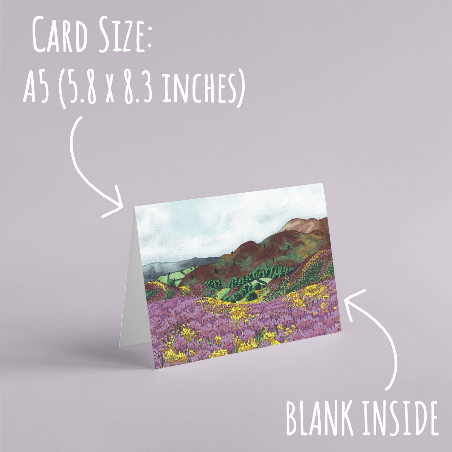 Rolling Hills Countryside Greetings Card standing with a pale purple background with the text card size: A5 (5.8 x 8.3 inches) and blank inside.