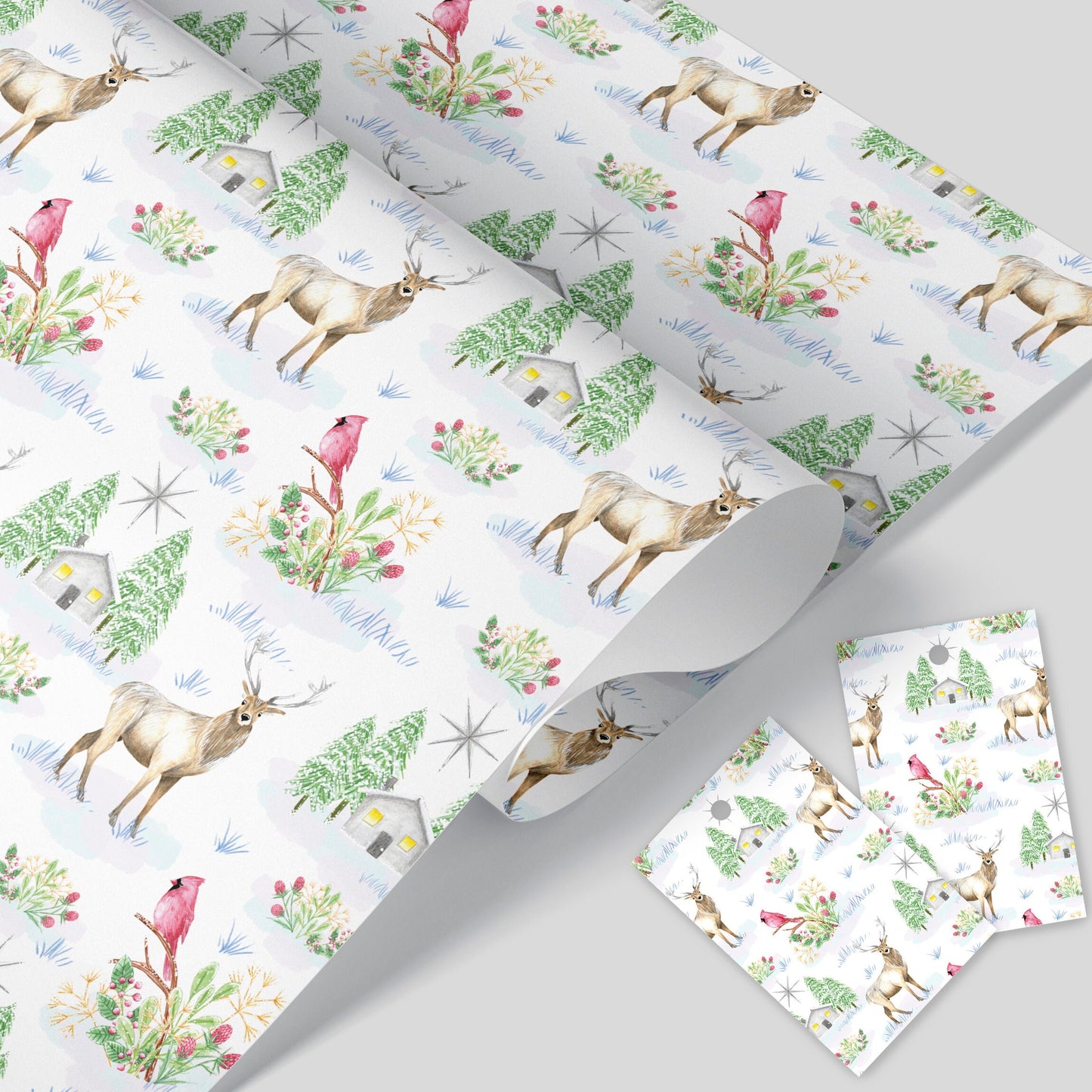 A rolled up Christmas wrapping paper with a winter scene including deer, birds, trees, and a lodge with a star and Christmas foliage, along with two tags.