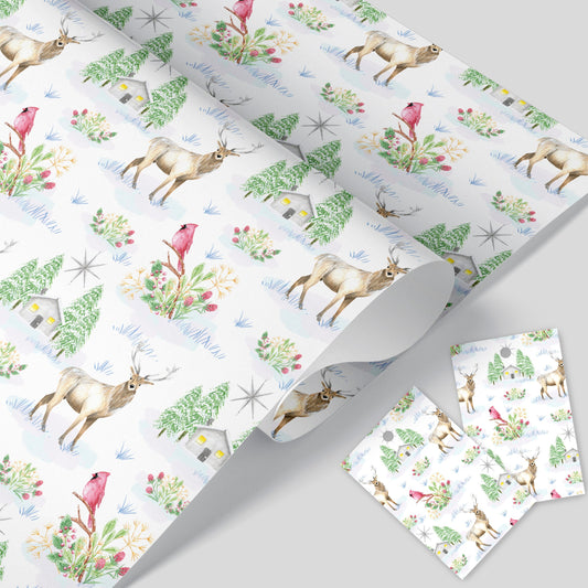 A rolled up Christmas wrapping paper with a winter scene including deer, birds, trees, and a lodge with a star and Christmas foliage, along with two tags.