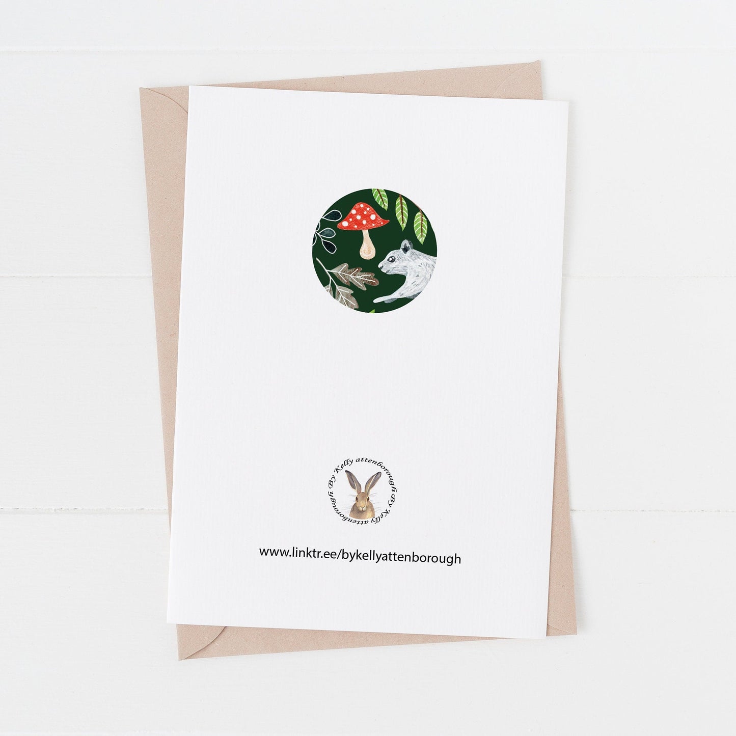 Squirrel & Rabbit Christmas Card back showing a logo and illustration in a circle. laying on a white background.