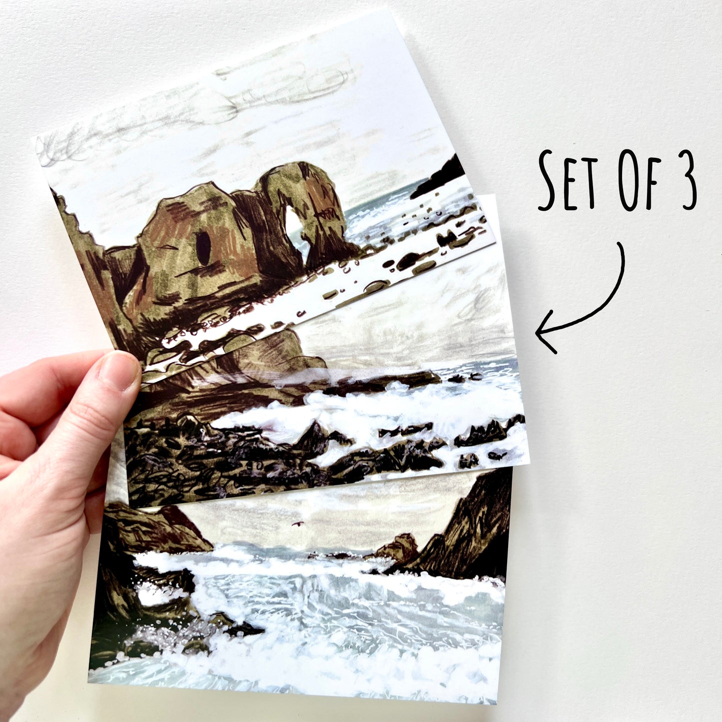 showing the Stormy Seas Postcard Set of 3 being held in a hand to show scale.