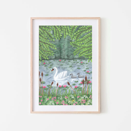 A framed art print depicting a white swan with cygnets on a lake, surrounded by greenery and flowers.