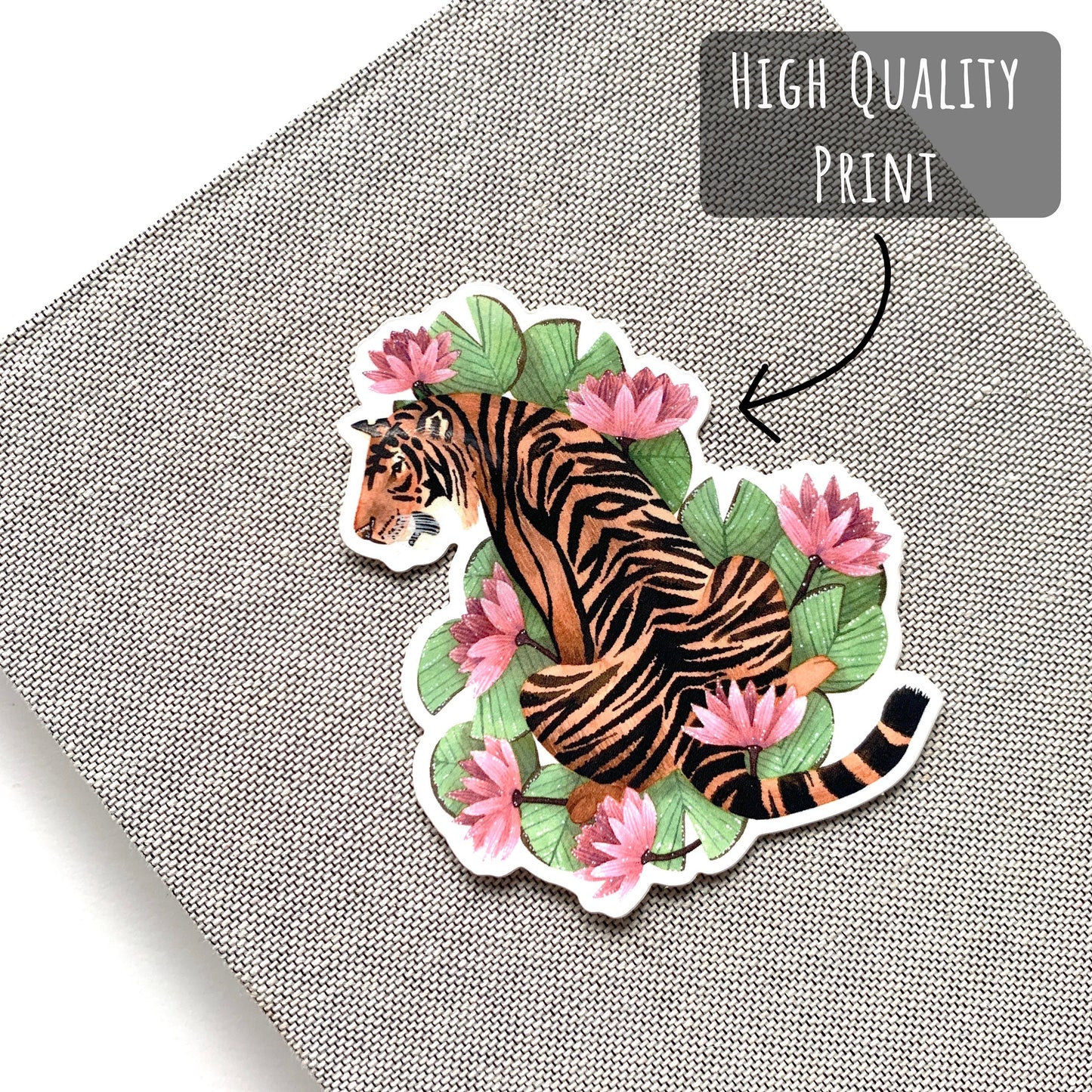 Tiger and Pink Lilies Sticker placed on the front cover of a notebook with the text high quality print.