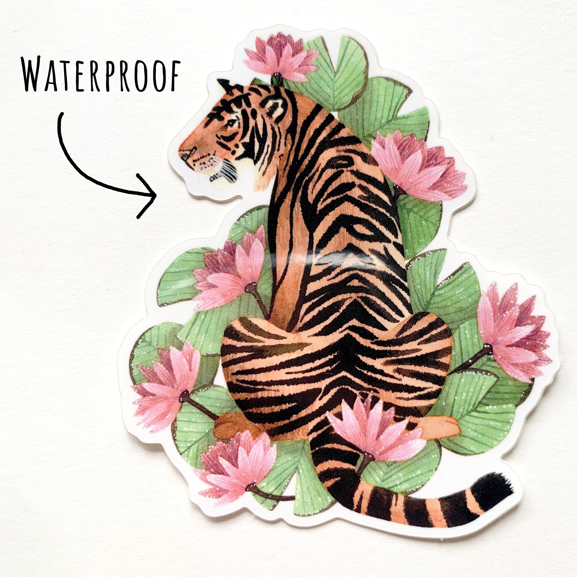 Tiger and Pink Lilies Sticker laying flat on a white surface with the text waterproof.