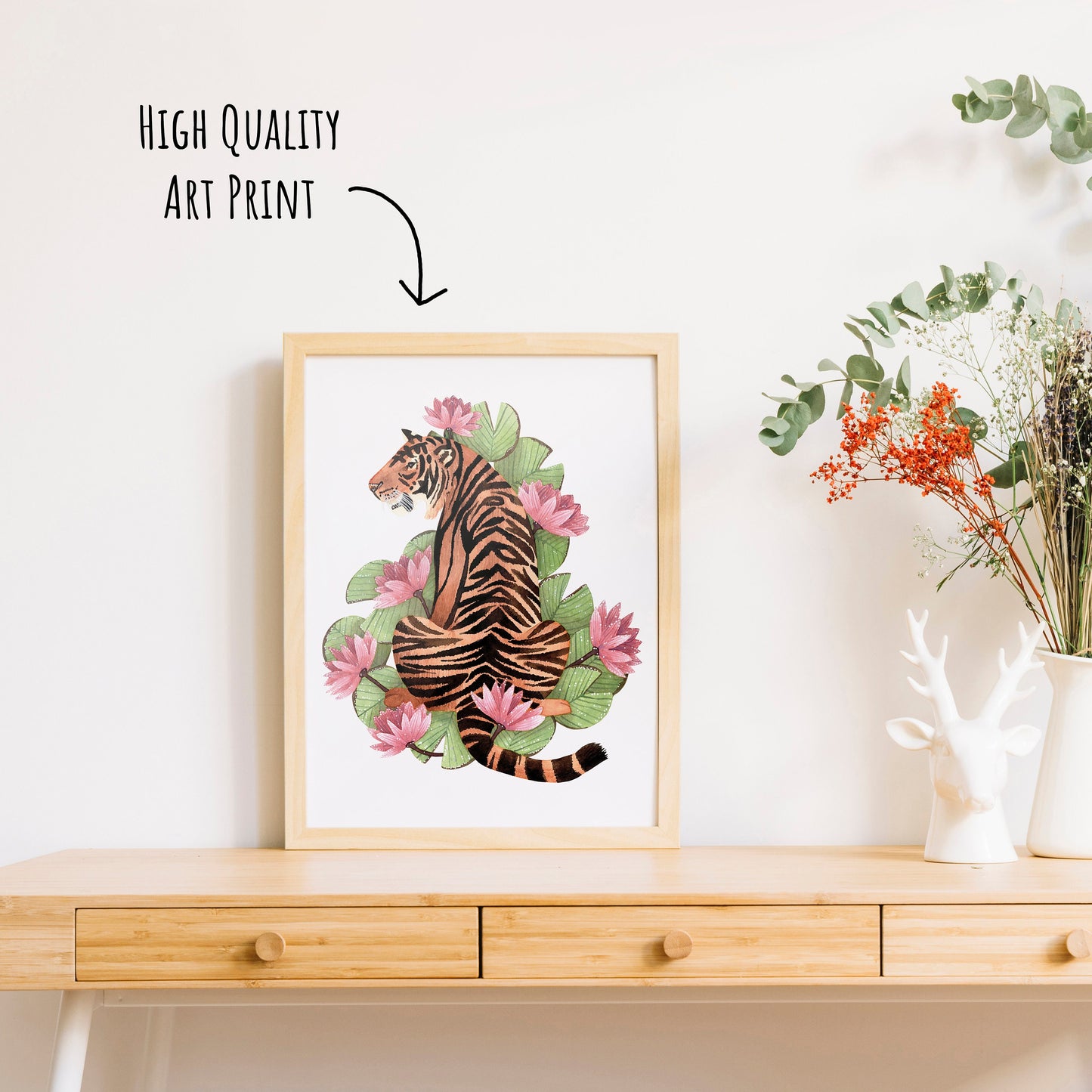Vibrant Tiger Art Print shown in a light wooden frame on a table top with a vase of dried foliage. (frame not included in purchase)