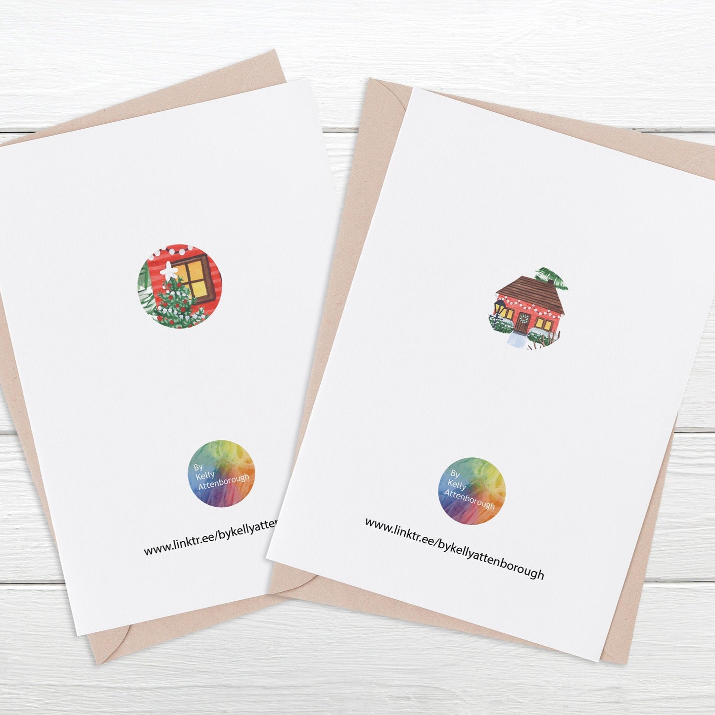 showing the back of the Village & Lodge luxury Christmas Cards featuring a logo at the bottom with and illustrated circle in the middle. Laying on a white wood surface.