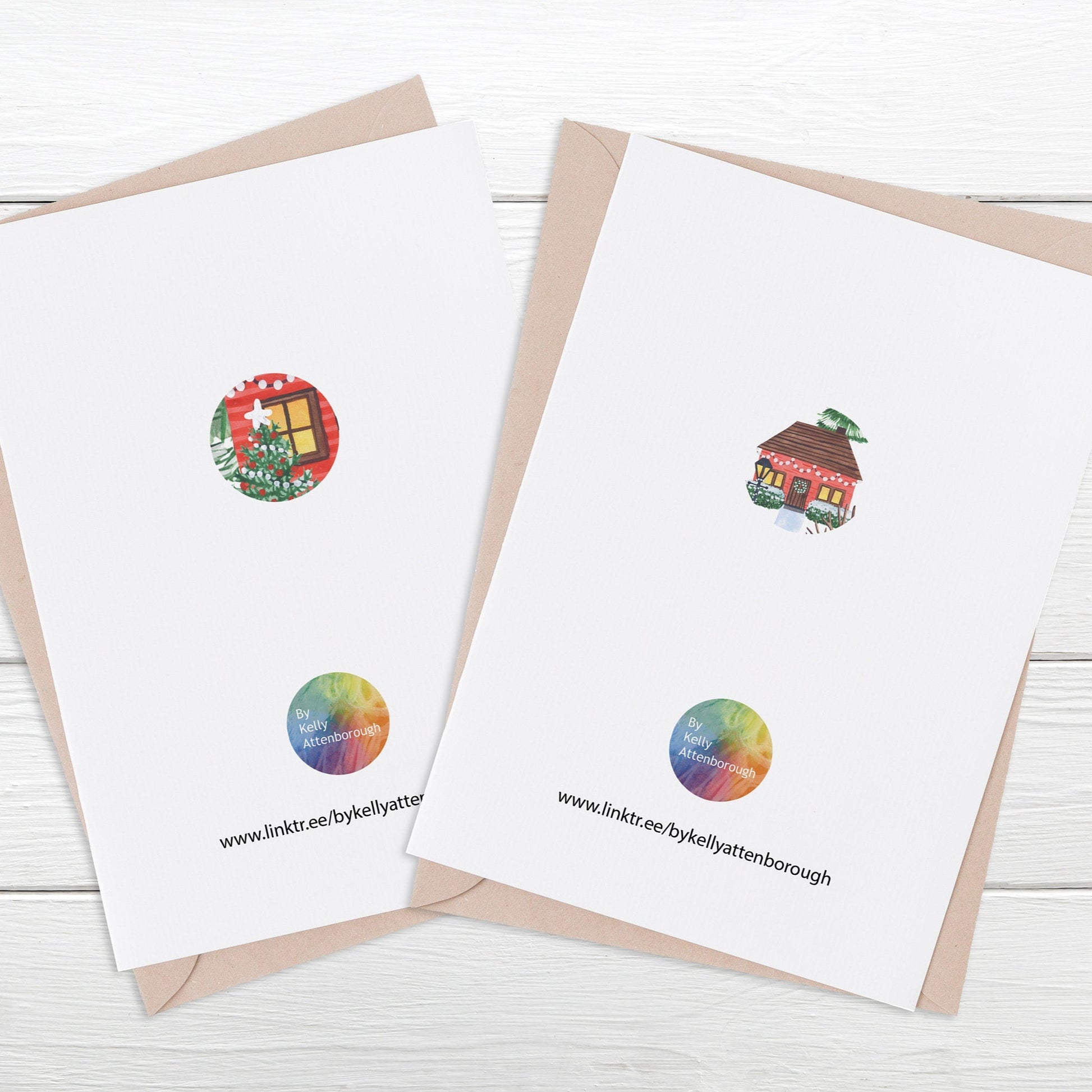 showing the back of the Village & Lodge luxury Christmas Cards featuring a logo at the bottom with and illustrated circle in the middle. Laying on a white wood surface.