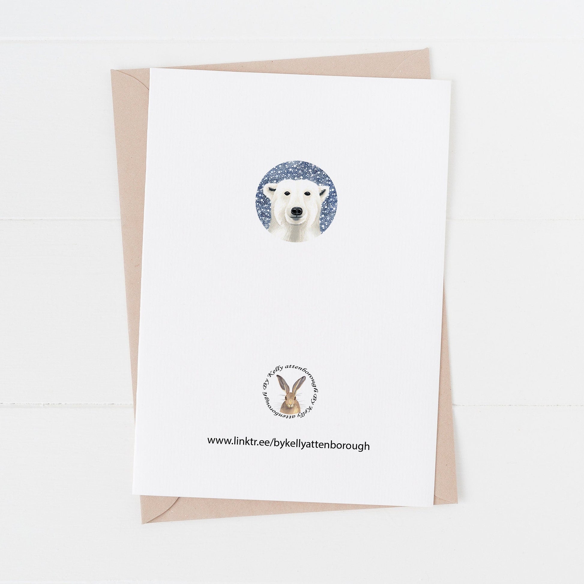 Showing the Back of the White Polar Bear Christmas Card with kraft envelope on a white surface.