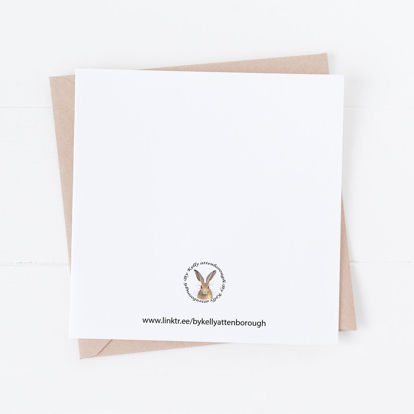 Wildflowers Birthday Card back showing the brand logo. laying on a white surface.