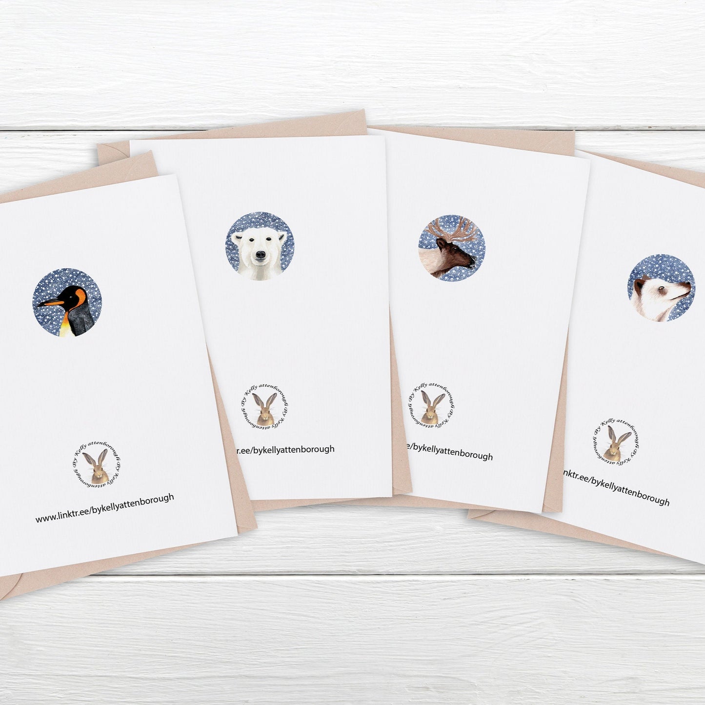 Showing the back of a set of greeting cards with animal illustrations laying on a white wooden surface.