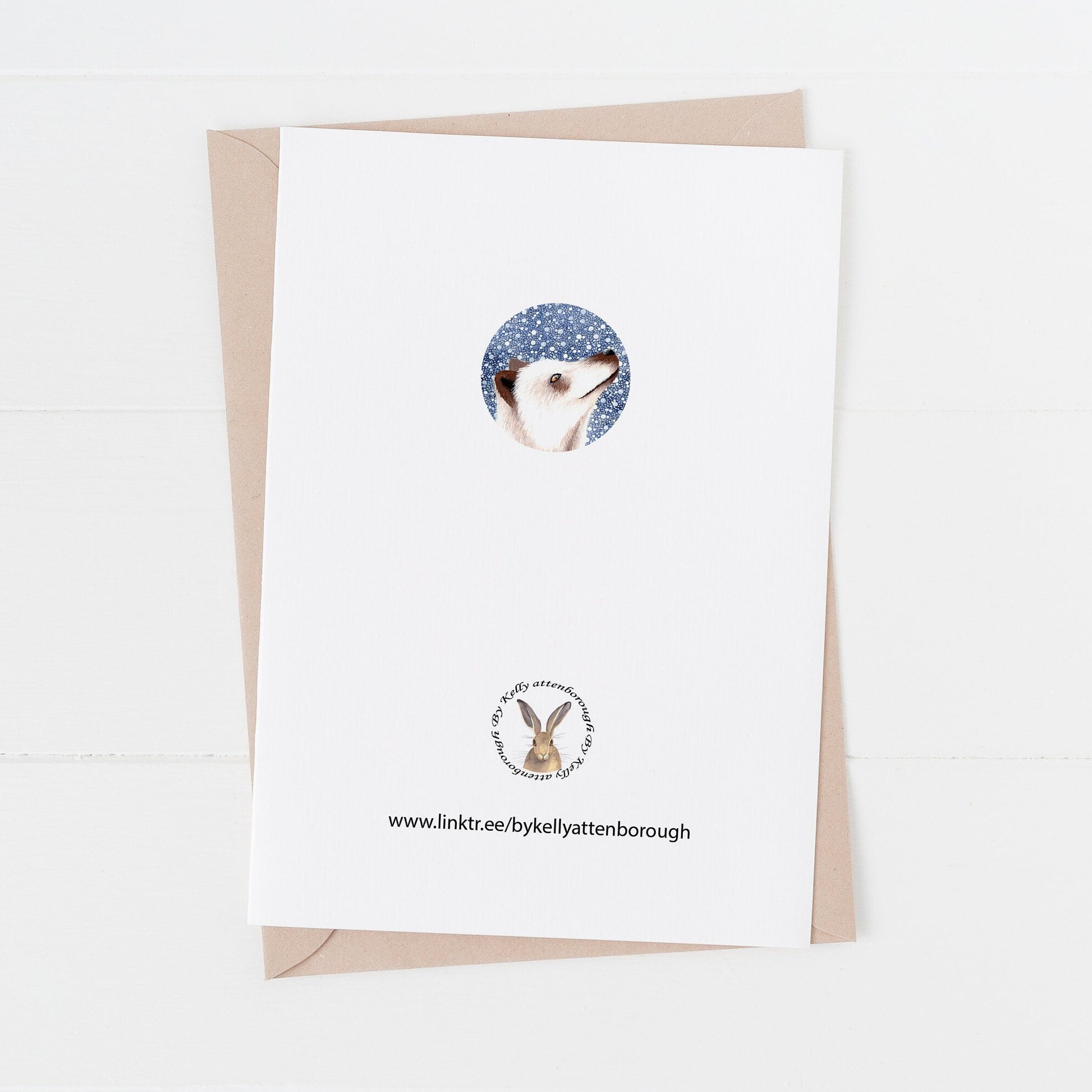 The back on the Winter Arctic Fox Christmas Card on a white surface.