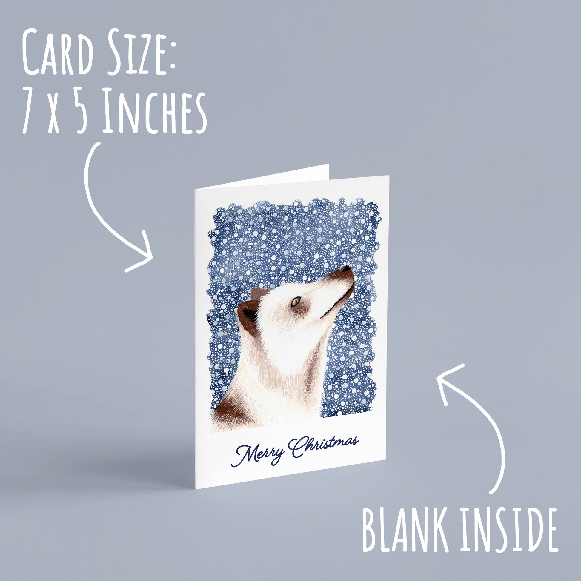 Winter Arctic Fox Christmas Card standing on a pale blue background. With the text card size: 7 x 5 inches and blank inside.
