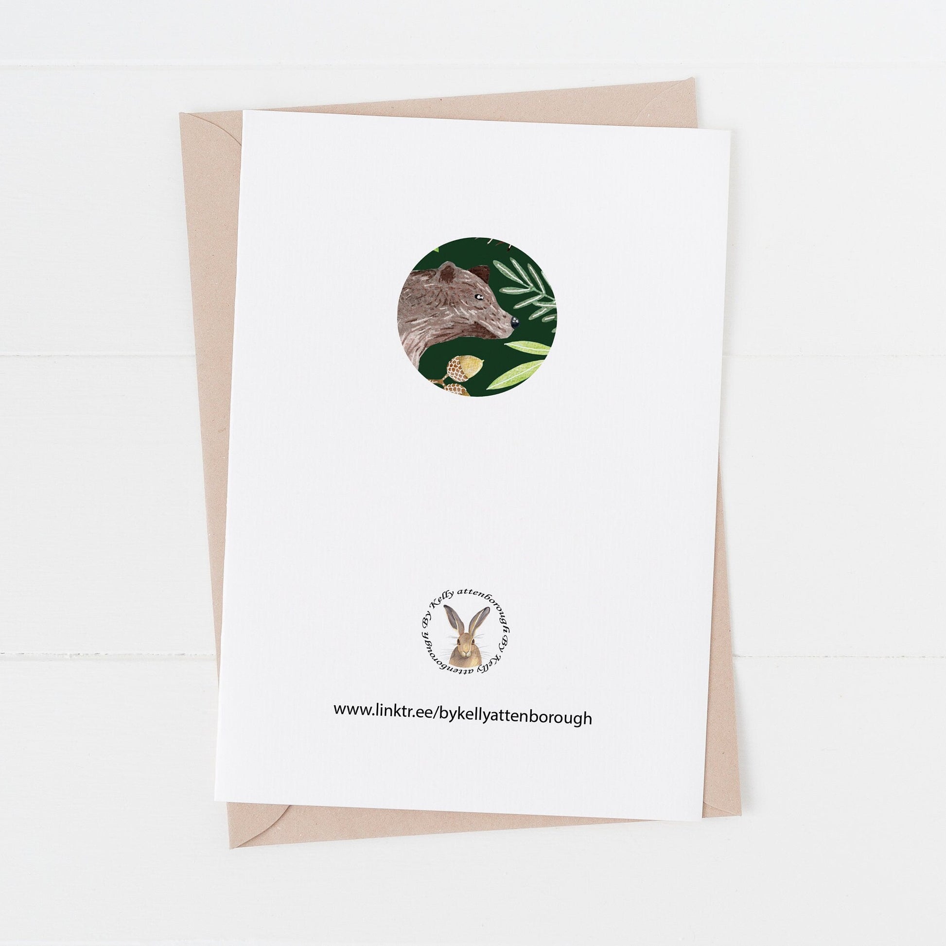 Greeting card back with a small circular design and logo on. on a white surface.