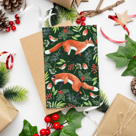 Christmas greetings card with fox design surrounded by Christmas decorations on a white background