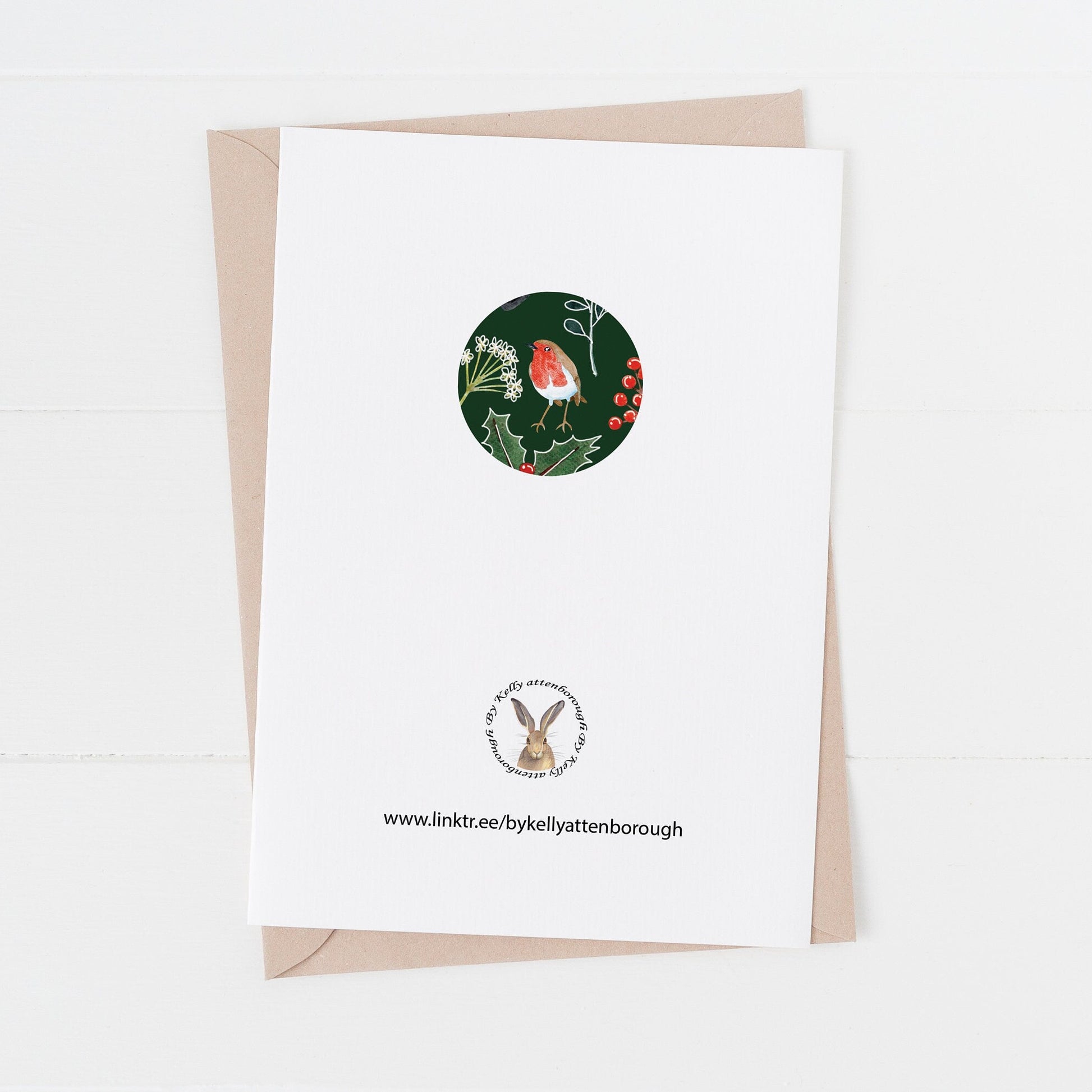 back of a Greeting card with a robin and holly design on a white background