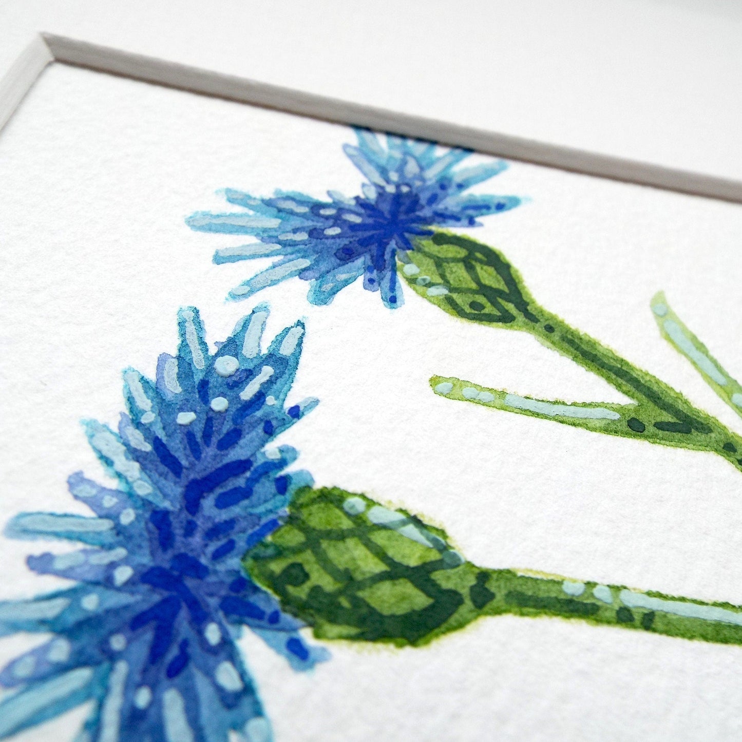 A close up of a cornflower painting showing the details of the blue flowers and stems