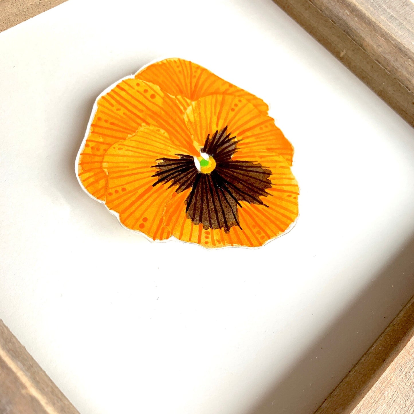 Orange and black pansy flower painting in a wood frame showing a close up