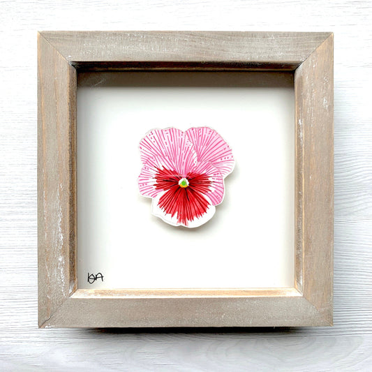 A hand-painted watercolor painting of a pink, red, and white pansy flower, framed in a rustic washed effect box frame.
